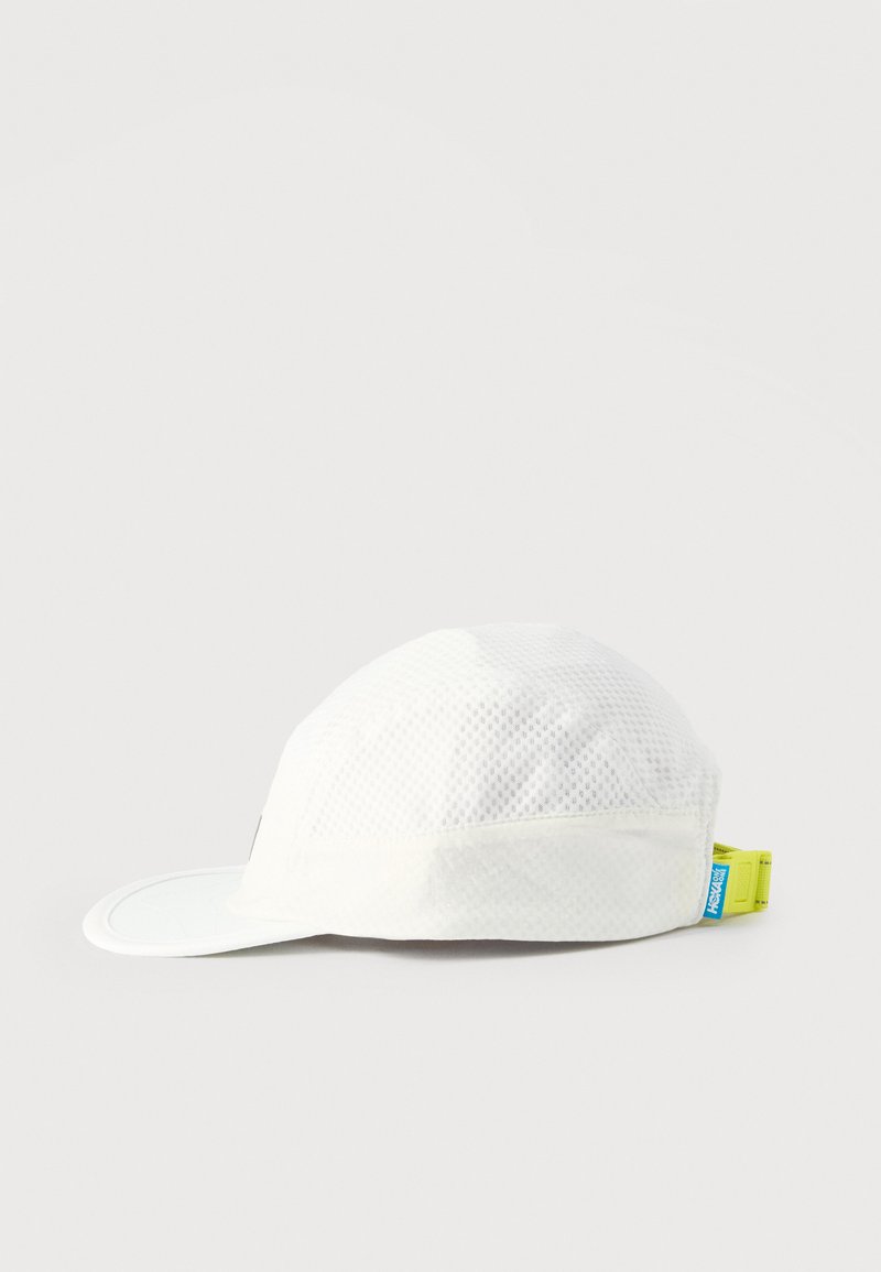 White mesh athletic cap with neon yellow adjustable strap and blue logo tag on a plain light background, shown from the side.