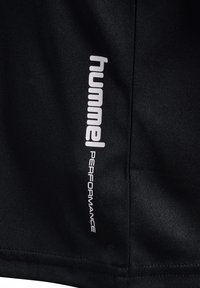 Shorts de sport noirs en tissu lisse, ornés d'un logo blanc "Hummel PERFORMANCE" sur le côté. Design simple sans motifs.