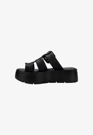 Czarne sandały na platformie z trzema szerokimi paskami, gładką fakturą, grubą podeszwą i minimalistycznym designem. Idealne do noszenia na co dzień.