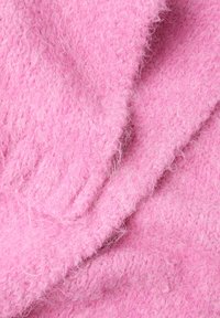 Roze textiel met een zachte, fuzzy oppervlakte, met een subtiel breipatroon en een oneven weefstructuur.