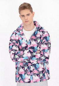 Jachetă colorată, cu modele, având flamingo roz și motive tropicale pe un fundal închis. Fabricată dintr-un material ușor, cu închidere cu fermoar.