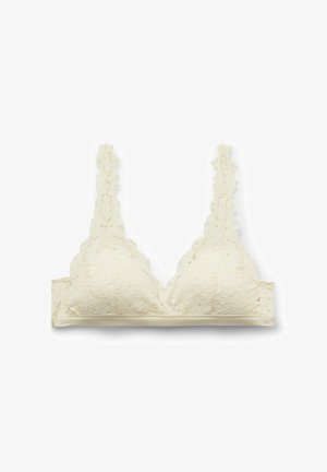 Kremowy koronkowy biustonosz typu bralette z kwiatowymi wzorami, falistymi krawędziami i regulowanymi koronkowymi ramiączkami, rozłożony na płasko na białym tle.