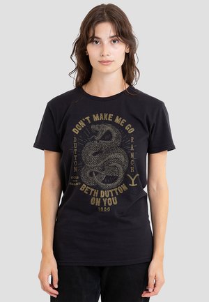Black cotton t-shirt featuring a gold serpent graphic and text: "Don’t Make Me Go Beth Dutton Ranch 1886." Short sleeves, crew neckline.