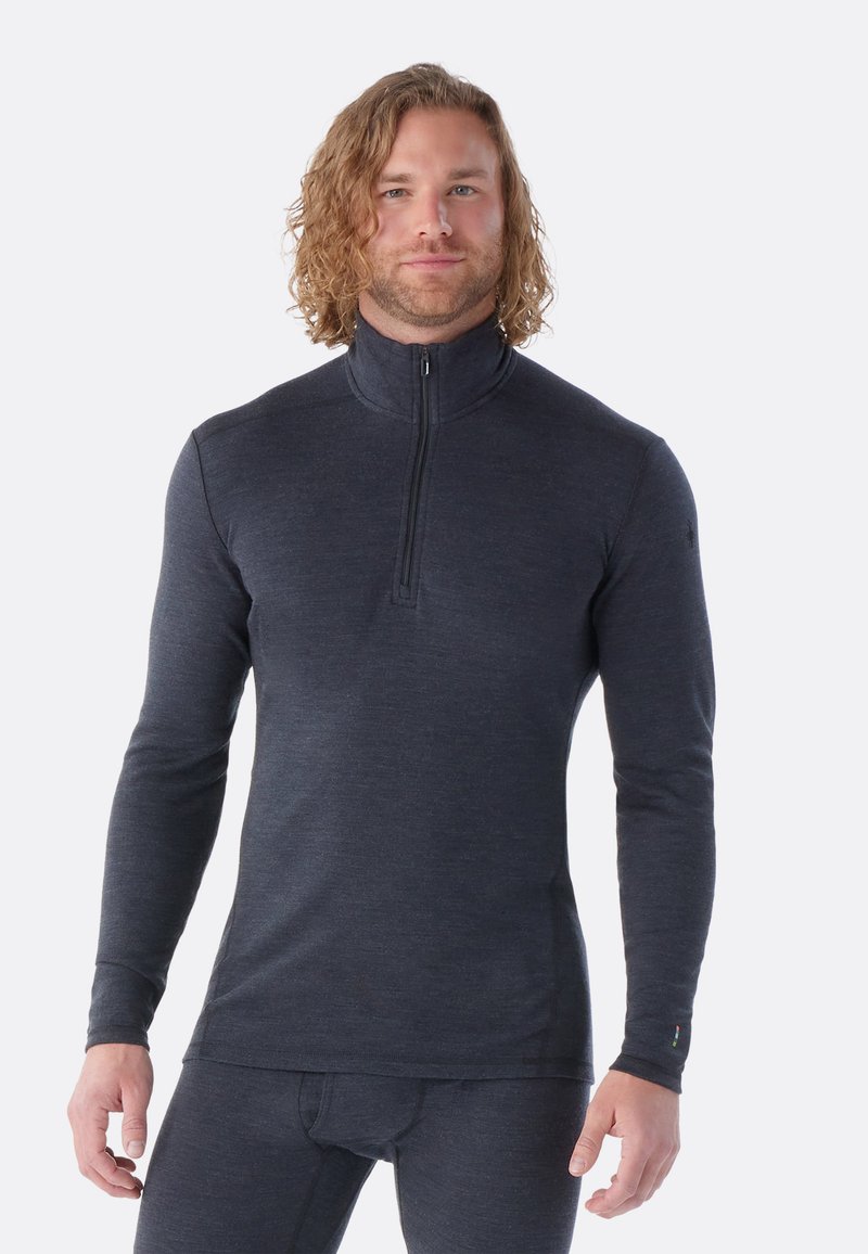 Maglietta a maniche lunghe zip-up di un grigio scuro, realizzata in un materiale liscio e elasticizzato, con colletto alto e vestibilità aderente, dotata di un logo sulla manica.