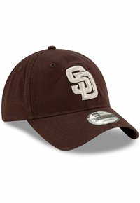 Casquette réglable marron avec un logo "SD" brodé en crème, design à six panneaux et visière incurvée. Tissu doux avec des détails texturés.