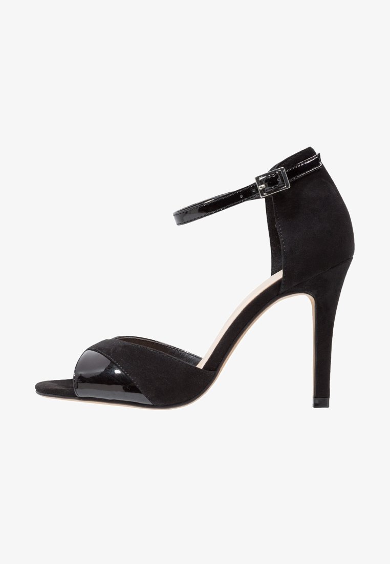 Musta korkokengät, joissa on kiiltävä varvaskappale ja mokkanahkainen päällinen. Contains an ankle strap with a buckle ja tyylikäs stiletto-korko.