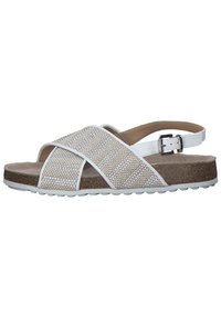 White sandal with woven textured upper, crossed straps, adjustable buckle, and a cork footbed, featuring a rubber sole with grip texture.