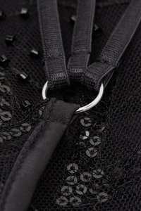 Černá síťovaná taška s korálkovými detaily, vybavená stříbrným kovovým kroužkem a silnými černými popruhy. Textura působí složitě díky vrstveným materiálům.