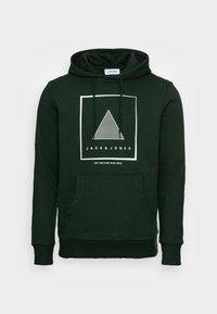 Tmavě zelená mikina s kapucí a přední kapsou, bílý trojúhelníkový grafický vzor a text "JACK & JONES" uvnitř bílé čtvercové obruby na hrudi.