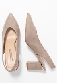 Taupe mockasklacksandaletter med klackar och spetsiga tår, visade från ovan och sidan på en vit bakgrund.