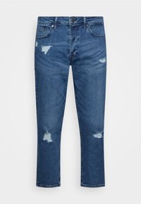 Jeans de ganga azul escura com corte reto, apresentando remendos desgastados e uma textura desbotada. Inclui cinco bolsos e um fecho de botão de metal.