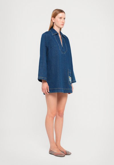 Denim dress, dark blue, with a V-neck and long sleeves. Features a front pocket with a multicolored embroidered design.