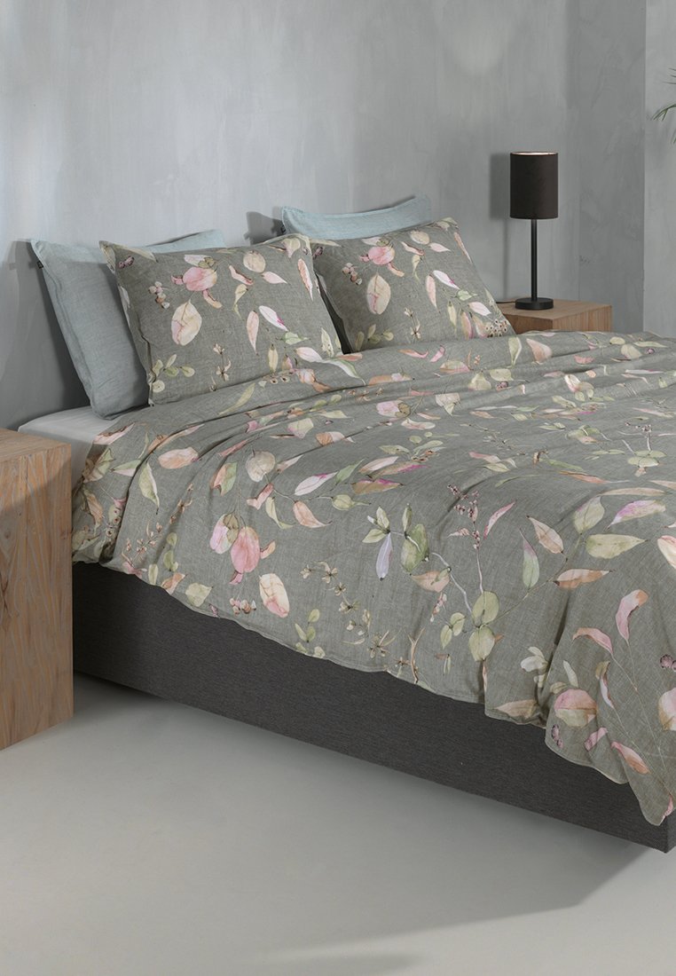 Juego de ropa de cama con estampado floral que presenta un fondo gris claro con hojas rosas y verdes, acompañado de fundas de almohada a juego sobre una base de cama oscura.
