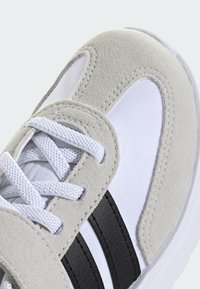 Baskets en suède gris clair avec des panneaux en maille blanche, des rayures en cuir noir et des lacets blancs. Comprend un col rembourré et une semelle texturée.