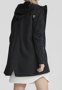 Černý dlouhý kabát s kapucí, se staženým pasem, hladkou texturou a bočními rozparky. Logo na horní části zad dotváří design.