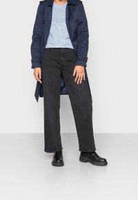 Navy trench coat, light blue knit sweater, black wide-leg jeans, black chunky boots. Smooth fabric, structured design, ribbed texture on sweater.