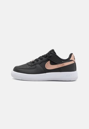 Sneaker in pelle nera con dettagli in oro rosa, lacci piatti, perforazioni sulla punta e suola in gomma bianca. Presenta il marchio Nike.