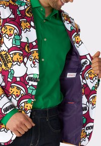 Farbenfrohe Anzugjacke mit cartoonhaften Weihnachtsmännern und festlichem Text; weißer Außenstoff, lila Futter, grüne Akzente und eine Knopfverschluss.