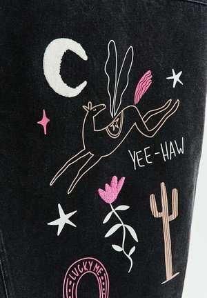 Abstrakcyjny kontur konia z skrzydłami, półksiężycem, gwiazdami, różowym kwiatem, kaktusem i napisem „YEE-HAW” na ciemnym tle materiału.