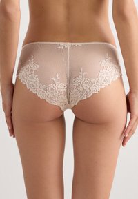 Beige kanten slipje met een textuur van rasterpatroon, bloemenkant langs de randen en een zachte, naadloze tailleband.