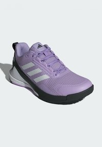 Purple athletic shoe with mesh upper, black rubber sole, and three silver stripes. Features padded collar and textured accents.