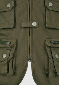 Oliwkowa kamizelka z płótna z wieloma kieszeniami, srebrnymi zapięciami na napy oraz zamkiem błyskawicznym z przodu. Teksturowany materiał o trwałym wykończeniu.
