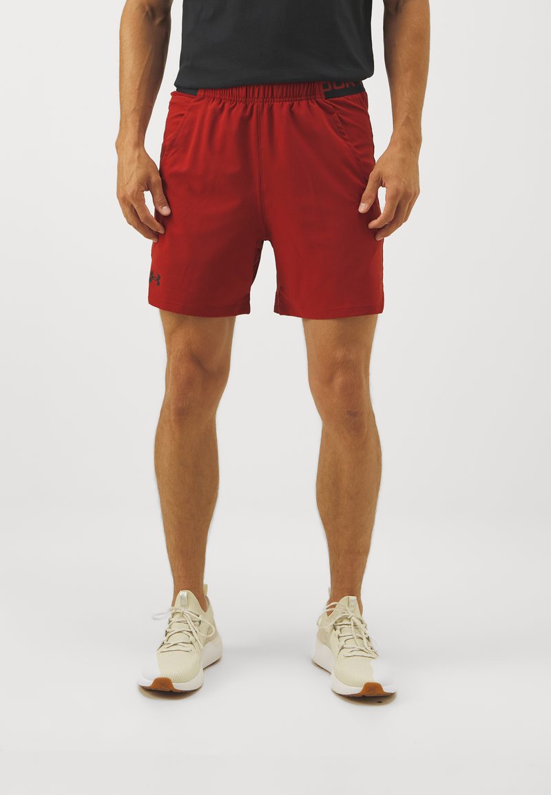 Rote Sportshorts mit elastischem Taillenbund und seitlichen Taschen, mit einem Logo am linken Saum. Glattes Material und knielange Passform.
