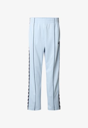 Helerohelised spordipüksid mustade küljeribadega, elastse vöökohaga ja kitseneva lõikega. Valmistatud pehmest, siledast kangast ning tal on puusal logo.