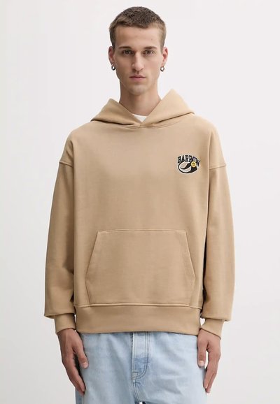 Sudadera beige con un gran bolsillo frontal, corte relajado, puños acanalados y un logo gráfico en el lado izquierdo del pecho. Hecha de una suave mezcla de algodón.