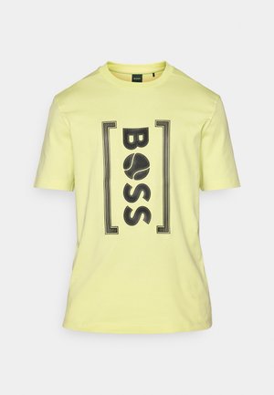 Yellow cotton t-shirt featuring a black graphic print of the word "BOSS" framed by two rectangular accents. Round neckline and short sleeves.