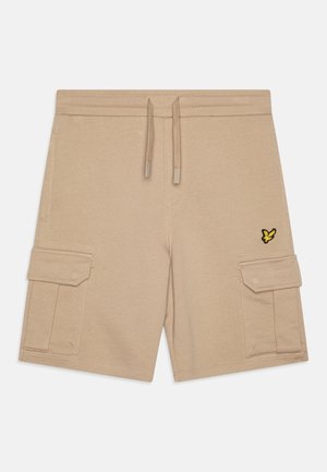 Short cargo beige avec taille à cordon, poches latérales à rabat et petit logo oiseau jaune et noir sur la poche droite.