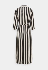 Robe longue noire et crème à rayures, avec des manches trois quarts, un col et une ceinture à la taille, présentant une silhouette décontractée et un tissu léger.