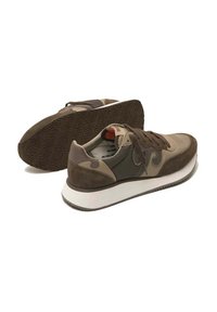 Scarpe sportive marroni con un mix di suede e materiali sintetici, superficie liscia, punta arrotondata e una robusta suola bianca con grip testurizzato.