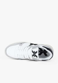 Sneaker bianca e grigia con logo a stella nera sul lato, lacci bianchi e branding sulla linguetta e sulla suola interna.