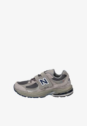 Baskets New Balance 2002R grises et beiges avec panneaux en maille, bande velcro et semelle coussinée, vues de côté droit.