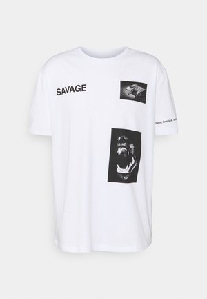 White t-shirt with black text "SAVAGE," images of an eagle head and a roaring animal, and partial text on the right sleeve.