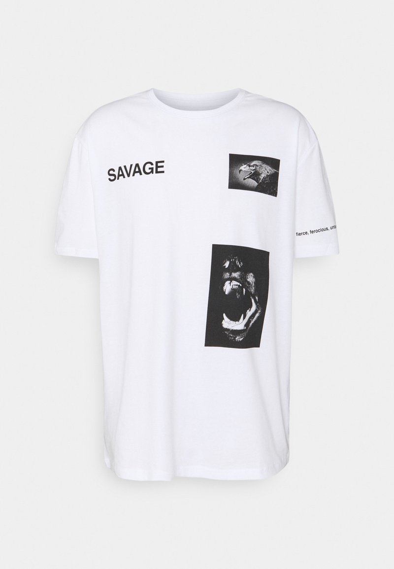 T-shirt blanc avec texte noir "SAVAGE", images d'une tête d'aigle et d'un animal rugissant, et texte partiel sur la manche droite.