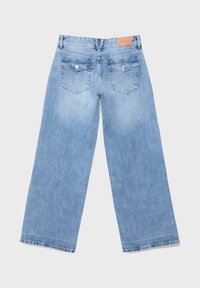 Hellblaue Jeans mit weitem Bein, von hinten gezeigt, mit zwei Knopfklappen-Taschen und einem Leder-Brandaufnäher am Bund.