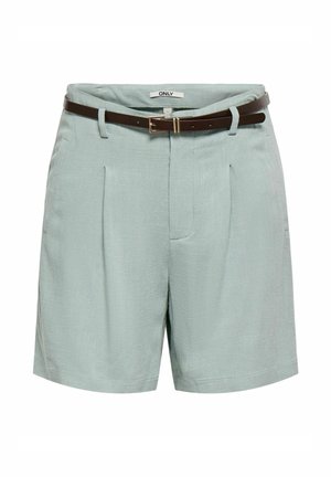 Shorts vert clair sur mesure avec plis avant et une ceinture fine marron foncé avec une boucle rectangulaire dorée.