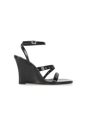 Black wedge sandal with three thin studded straps and an adjustable ankle strap with silver buckle.
