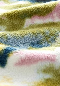 Fleece antklodė su švelniu paviršiumi, papuošta žaliais, mėlynais ir rožiniais atspalviais, kuri sukuria subtilų abstraktų dizainą.