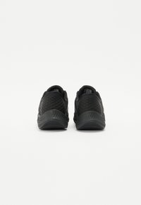 Black athletic shoes featuring a textured mesh upper, rounded shape, and a durable sole. Design focuses on comfort and flexibility.