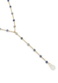 Collar de cadena de oro con cuentas redondas azules y un colgante blanco en forma de lágrima en el extremo. Las cuentas varían en tonalidad y textura.