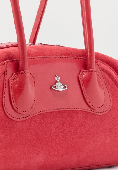 Κόκκινη τσάντα από σουέντ με δερμάτινες λαβές και μικρό ασημί έμβλημα σφαίρας και σταυρού στη μέση, ανάμεσα στις λαβές.