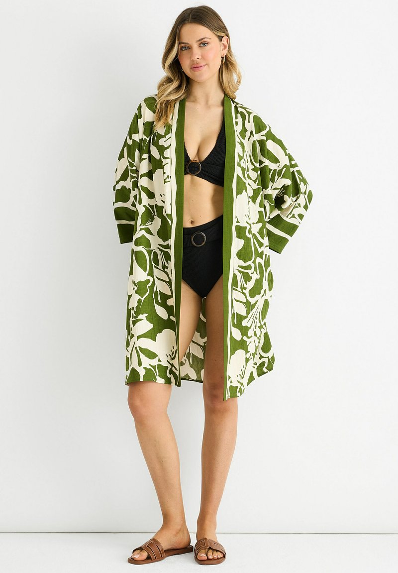 Green floral print kimono with white accents, open front, loose sleeves, and a knee-length cut, styled over a black swimsuit.
