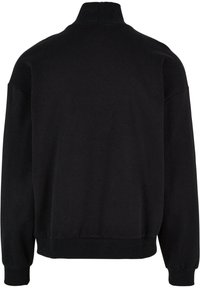 Svart sweatshirt med høy hals, lange ermer og ribbede mansjetter. Glatt tekstur, løs passform, og ingen synlige mønstre eller accenter.