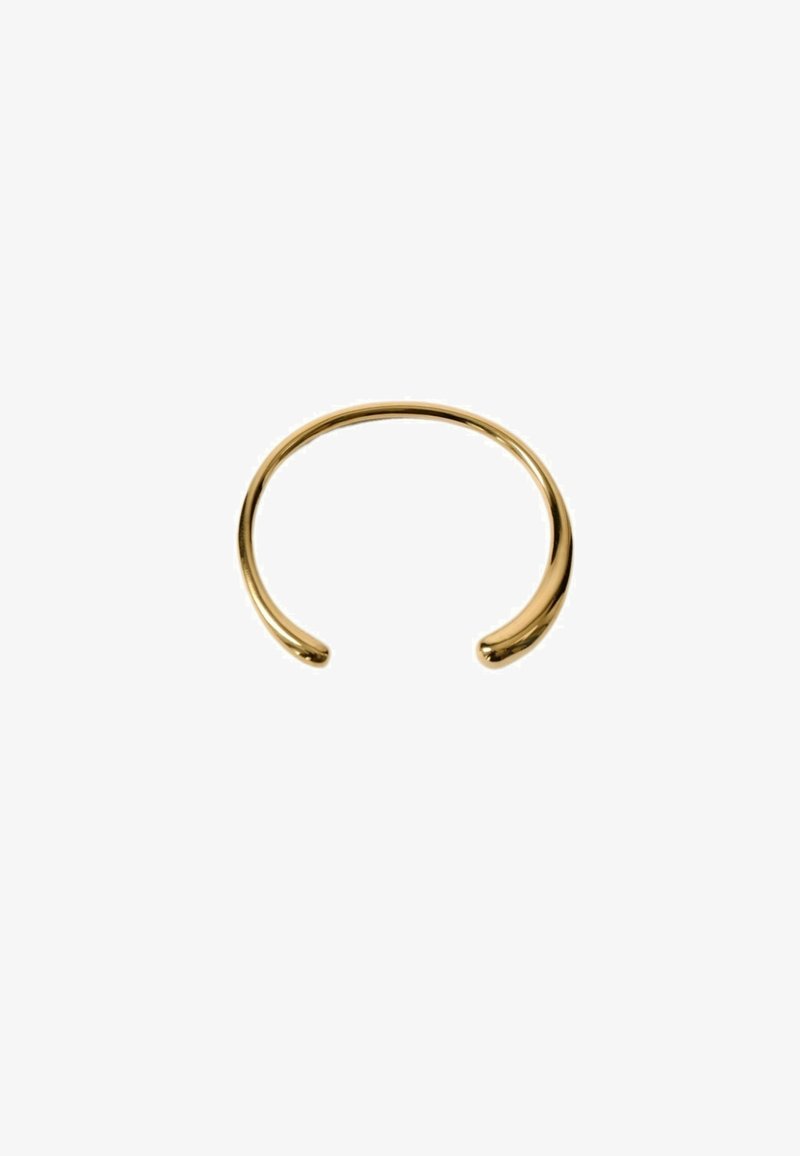 Brazalete de pulsera en tono dorado con un diseño elegante y abierto, textura suave y acabado pulido. Presenta extremos redondeados para mayor comodidad.