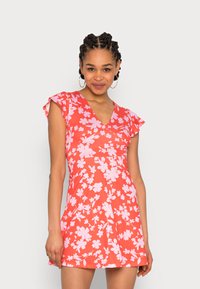 Vestido vermelho com manga curta e leve, apresentando um padrão floral em rosa claro. Design em V e forma esvoaçante com uma textura leve.