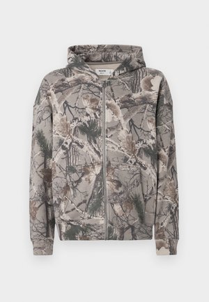 Mikina na zips s kapucňou, v kamuflážovom vzore s rôznymi stromovými konármi, listami a ihličkami v zemitých tónoch.