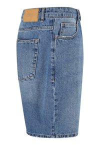 Jupe en denim bleu clair, coupe classique, mi-longue avec une pièce au dos de la taille, deux poches arrière et des détails de couture visibles.